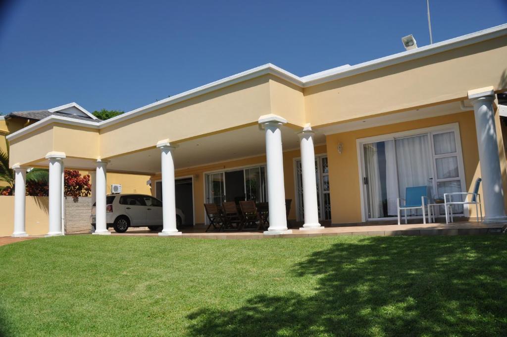 una casa con columnas blancas y un patio en King Palm Self-Catering Suite, en Durban