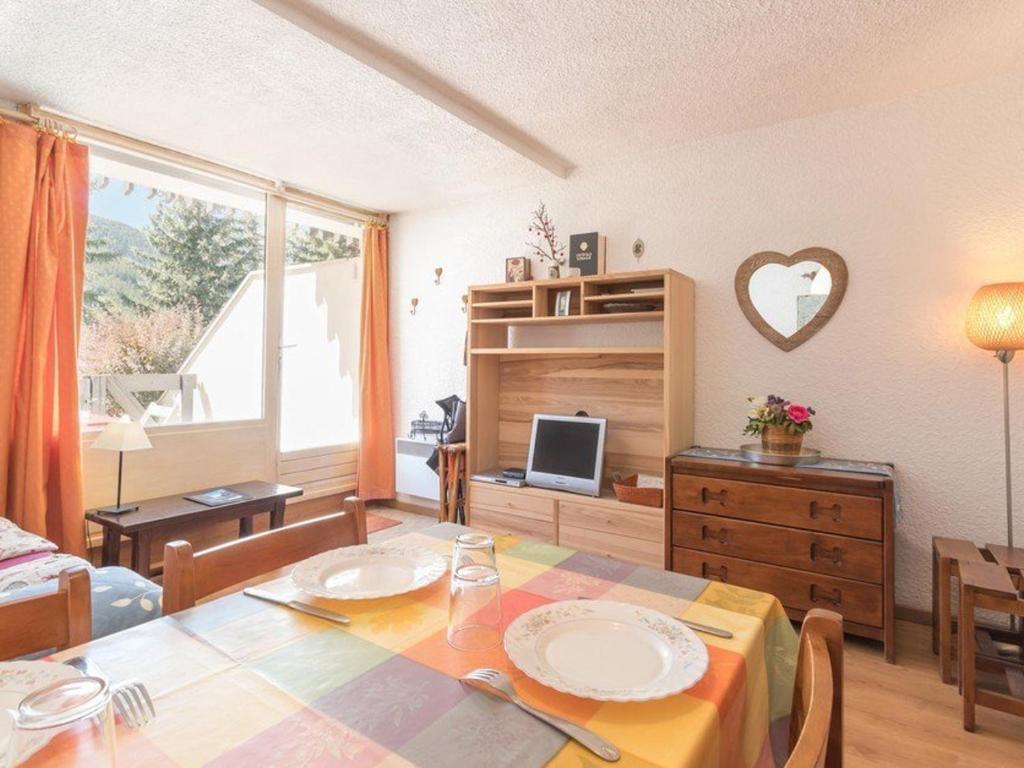 un salon avec une table à manger et un salon avec une table dans l'établissement Charmant studio à Chantemerle, terrasse, jardin, parking gratuit, 4 pers, proche Serre-Chevalier - FR-1-330E-53, à Saint-Chaffrey