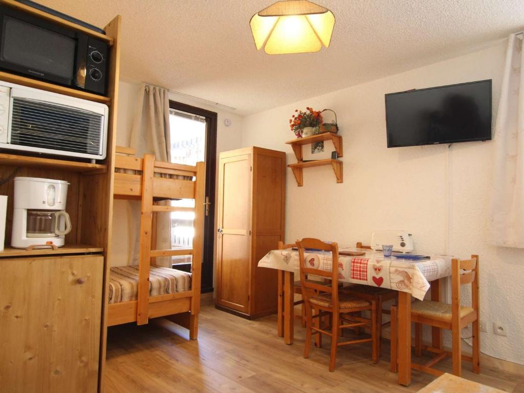 サン・シャフレにあるAppartement Saint-Chaffrey , 1 pièce, 3 personnes - FR-1-330E-64のテーブルと二段ベッド付きの小さな部屋です。