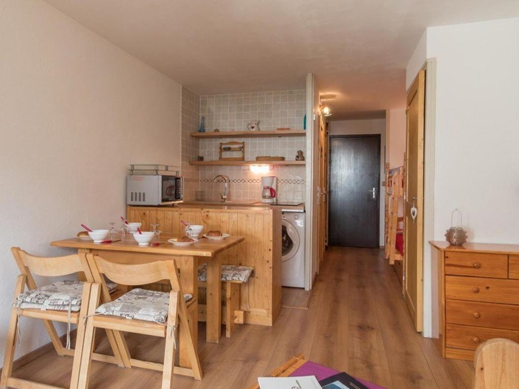 une cuisine avec une table et des chaises dans une pièce dans l'établissement Studio cosy à Serre-Chevalier - 4 pers, balcon, proche commerces, casier à ski - FR-1-330E-61, à Saint-Chaffrey