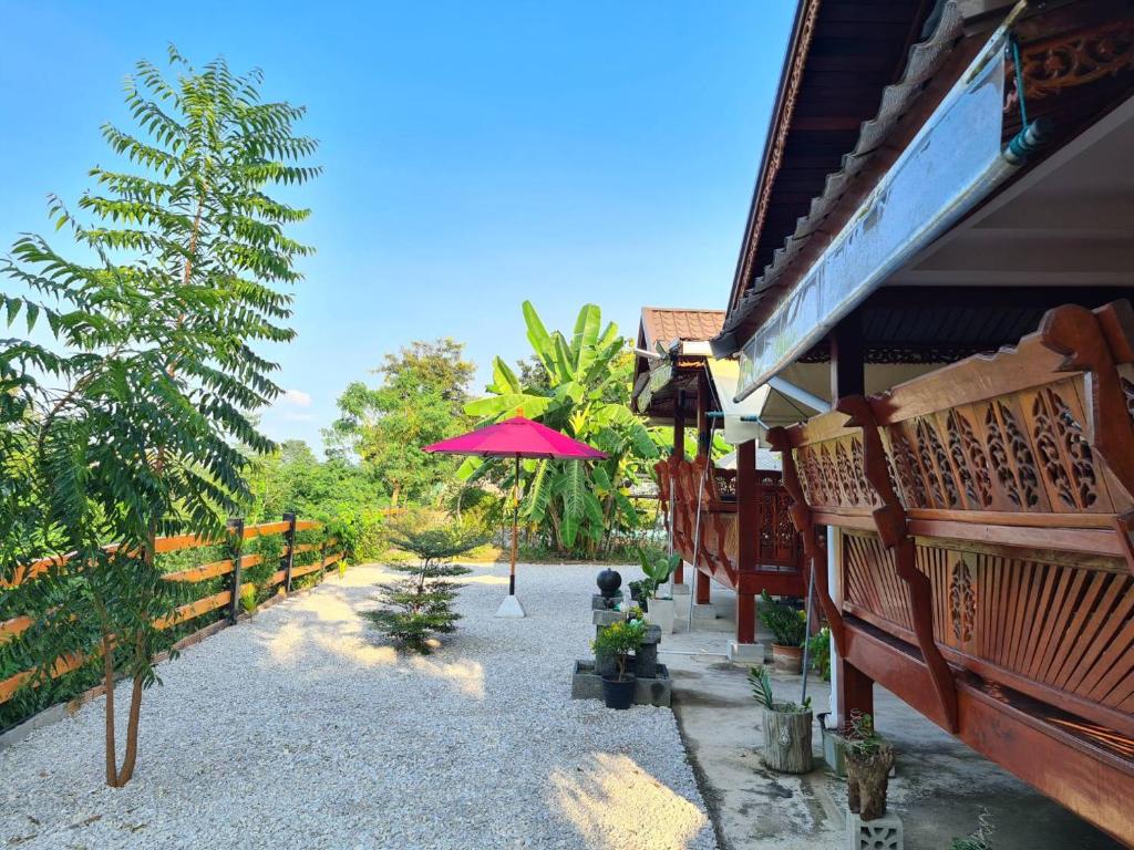 a patio with an umbrella next to a building at Lampang Hideaway Guesthouse in Lampang