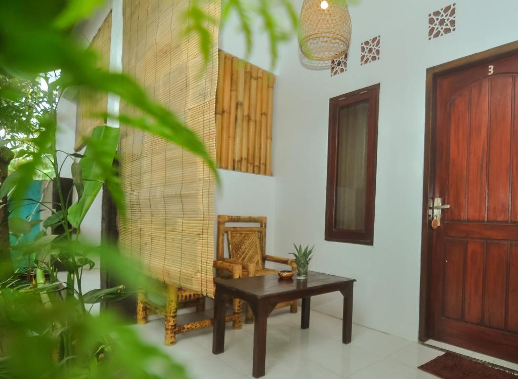 a living room with a wooden door and a table at Mango Tree House in Gili Trawangan