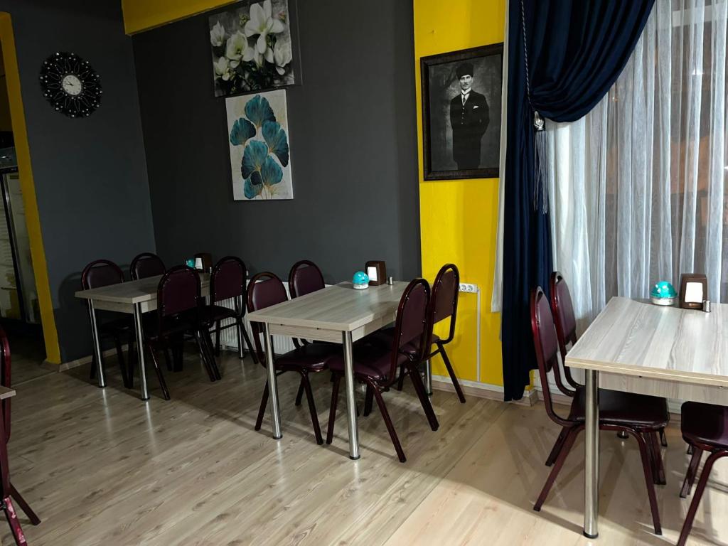 un comedor con mesas y sillas y una pared amarilla en M.H.T en Edirne