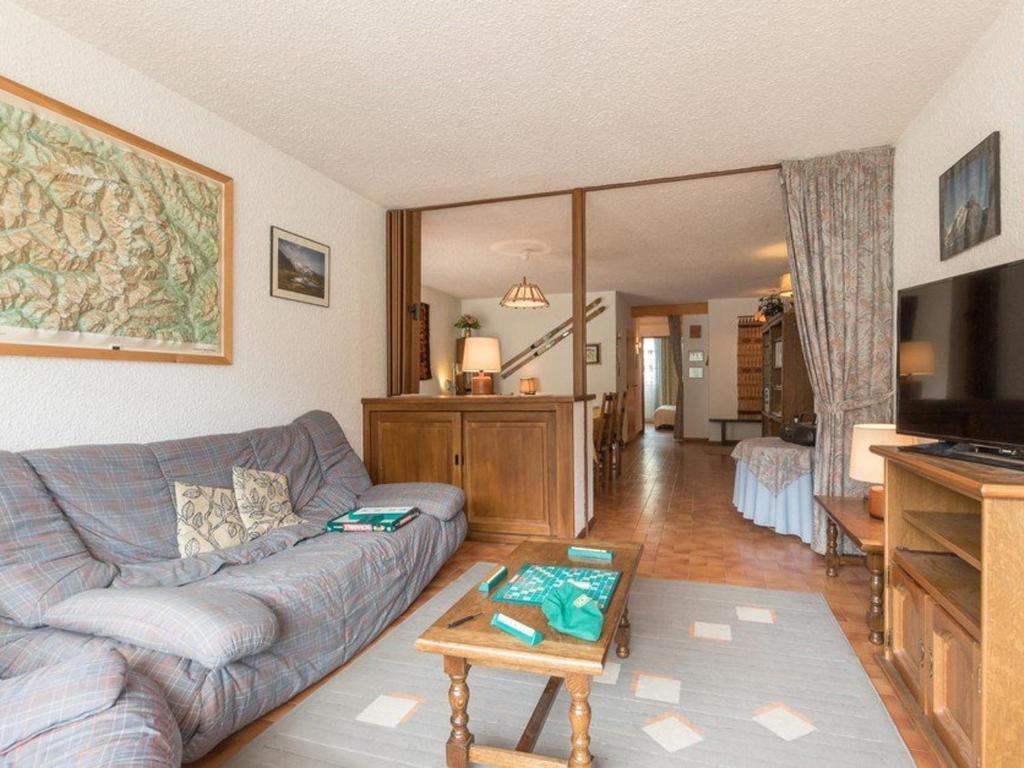 uma sala de estar com um sofá e uma televisão em Appartement Saint-Chaffrey , 3 pièces, 10 personnes - FR-1-330E-15 em Saint-Chaffrey