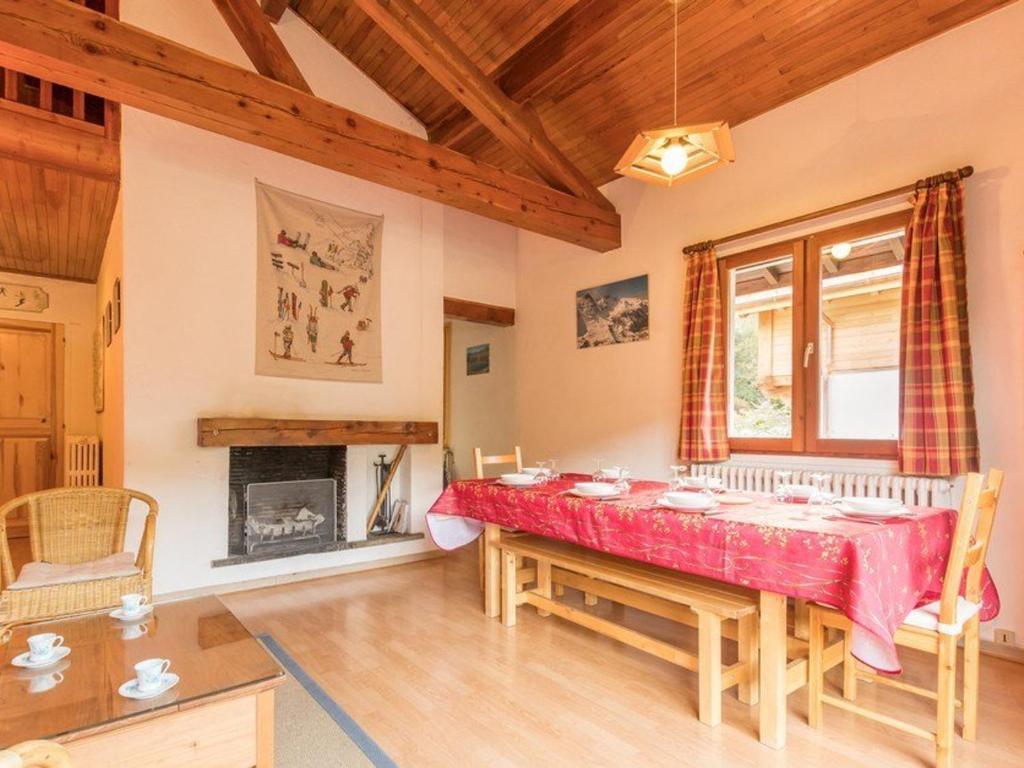 une salle à manger avec une table rouge et une cheminée dans l'établissement Chalet spacieux 8 pers. avec cheminée et TV à Serre-Chevalier, Chantemerle - FR-1-330E-19, à Saint-Chaffrey