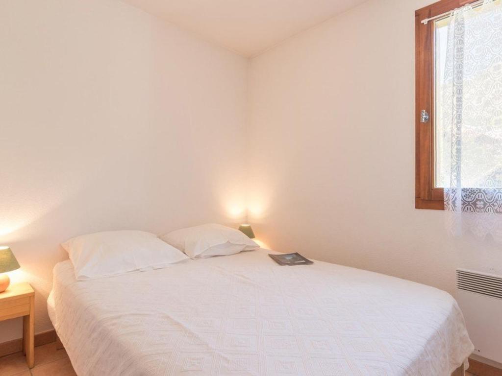 a white bed in a room with a window at Appartement Saint-Chaffrey , 3 pièces, 6 personnes - FR-1-330E-21 in Saint-Chaffrey