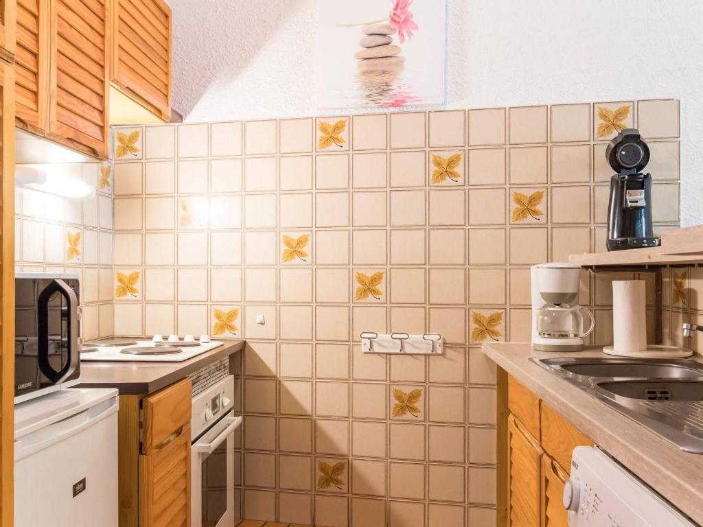 a kitchen with white appliances and yellow tiles at Appartement Le Monêtier-les-Bains, 2 pièces, 6 personnes - FR-1-330F-35 in Le Monêtier-les-Bains