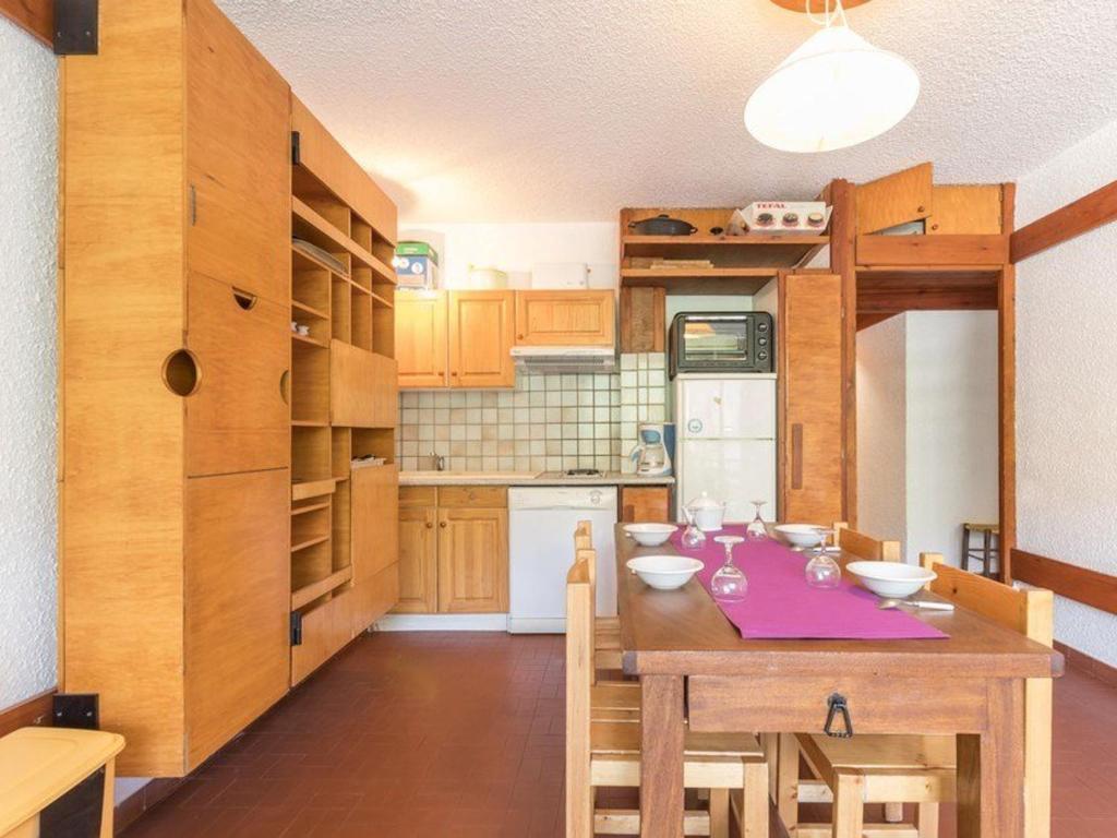 cocina con mesa de madera y mantel púrpura en Appartement Saint-Chaffrey , 2 pièces, 6 personnes - FR-1-330E-26, en Saint-Chaffrey