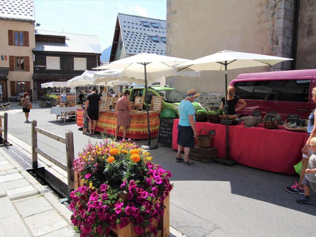 a group of people standing at an outdoor market with flowers at Appartement Le Monêtier-les-Bains, 2 pièces, 6 personnes - FR-1-330F-35 in Le Monêtier-les-Bains