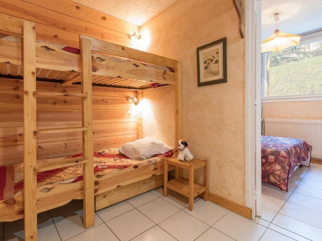 - une chambre avec des lits superposés et un ours en peluche assis sur une table dans l'établissement Appartement au pied des pistes avec jardinet - 2 pièces, 6 pers - Chantemerle, Serre-Chevalier - FR-1-330E-36, à Saint-Chaffrey