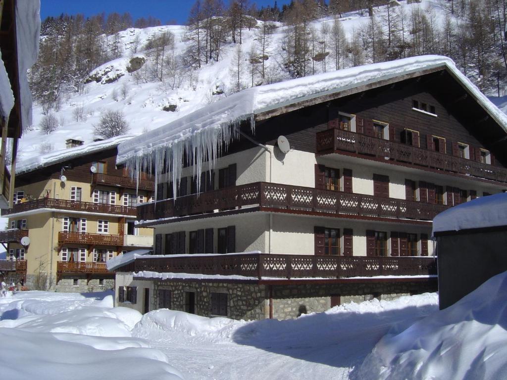 a building covered in snow with icicles hanging from it at Hotel Le Genepy in Tignes