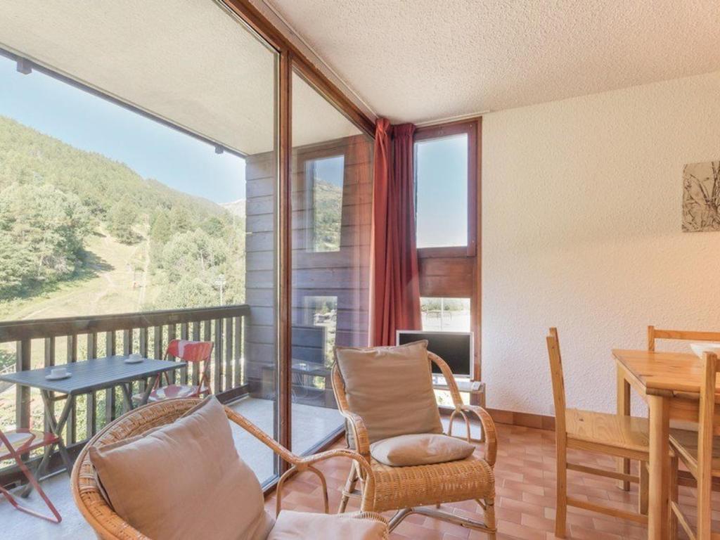 a room with a balcony with a table and chairs at Appartement familial à Serre-Chevalier : balcon, wifi, parking, à proximité des pistes - FR-1-330E-32 in Saint-Chaffrey