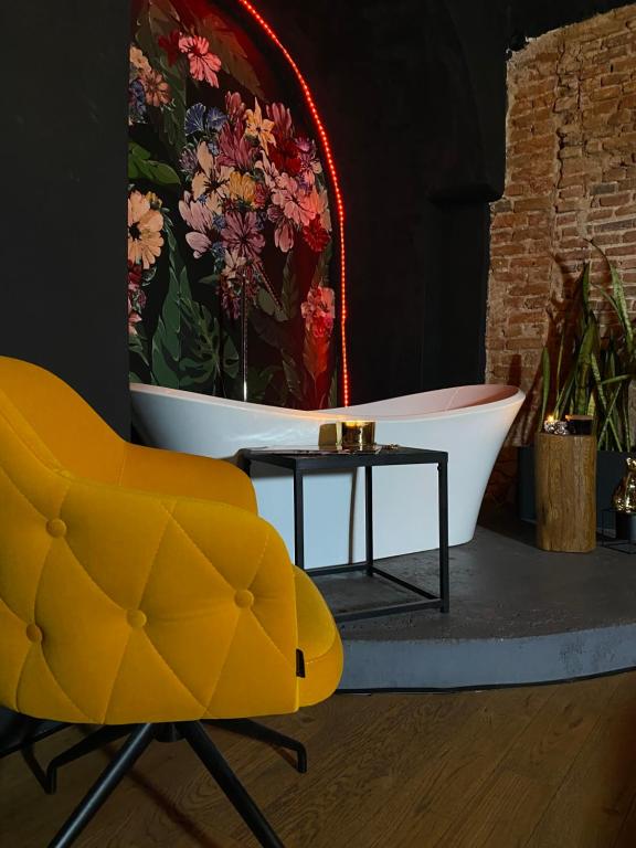 シビウにあるWorld Studio 5のバスルーム(バスタブ、黄色い椅子、テーブル付)