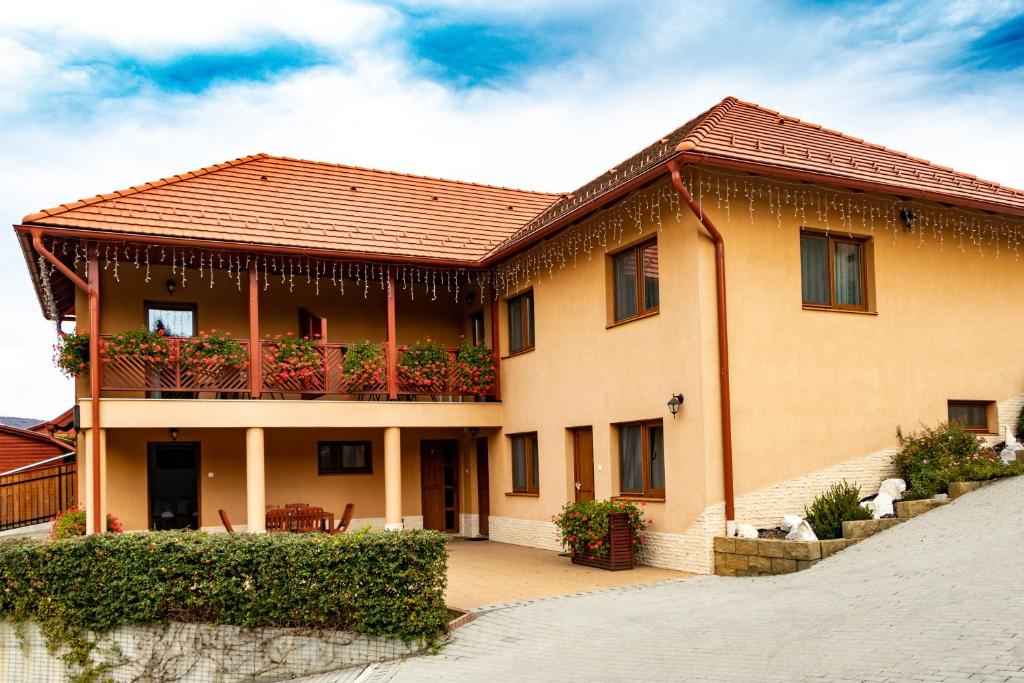 a house with a balcony with plants on it at Casa Tofi Vendégház in Praid