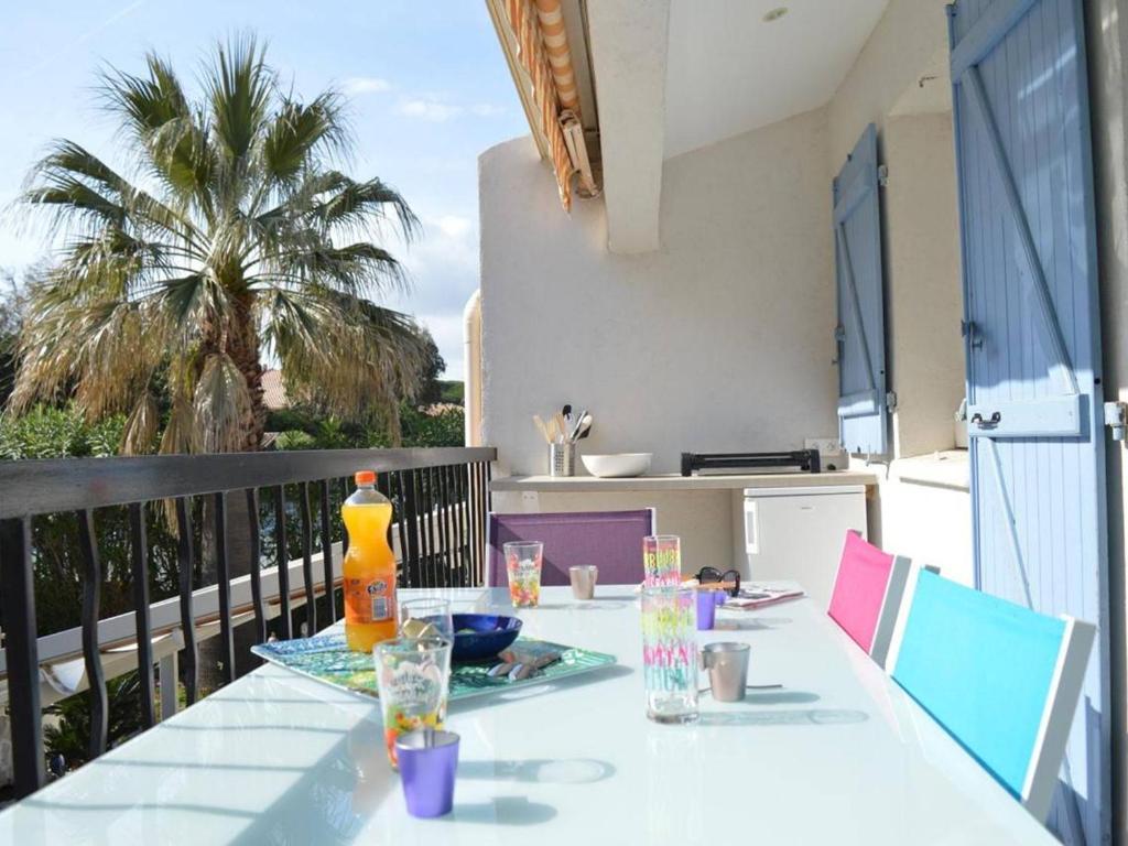 - une table blanche avec une boisson sur le balcon dans l'établissement Appartement 2P cabine rénové, clim, wifi, terrasse, parking, proche plage - Sainte-Maxime - FR-1-226-304, à Sainte-Maxime
