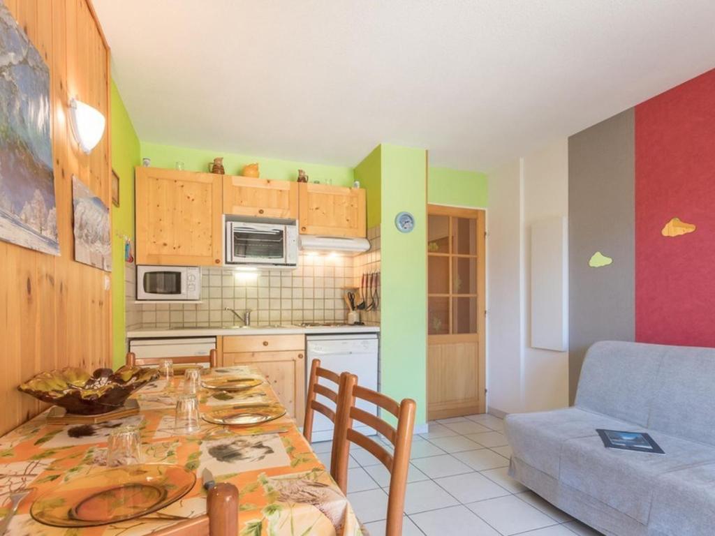 - une cuisine avec une table à manger et un canapé dans l'établissement Appartement cosy 4 pers à Chantemerle avec balcon, parking, proche pistes de Serre-Chevalier! - FR-1-330E-12, à Saint-Chaffrey
