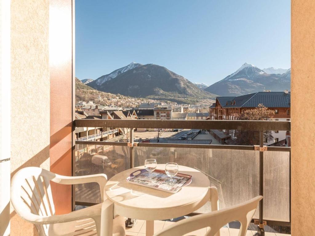d'une table et de chaises blanches sur un balcon avec vue sur les montagnes. dans l'établissement Apt 2P 4-6 Pers Briançon Proche Pistes, Balcon, TV, Cuisine Équipée, Animaux Admis - FR-1-330C-17, à Briançon