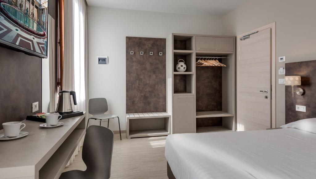 - une chambre avec un lit, un bureau et une table dans l'établissement Hotel Boston, à Montecatini Terme
