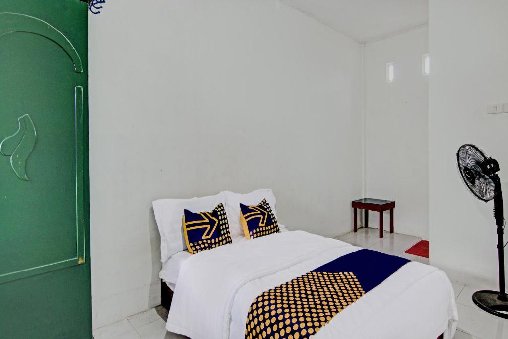 a bedroom with a bed with two pillows on it at SPOT ON 91950 Guest House TekNong Syariah in Bangkinang