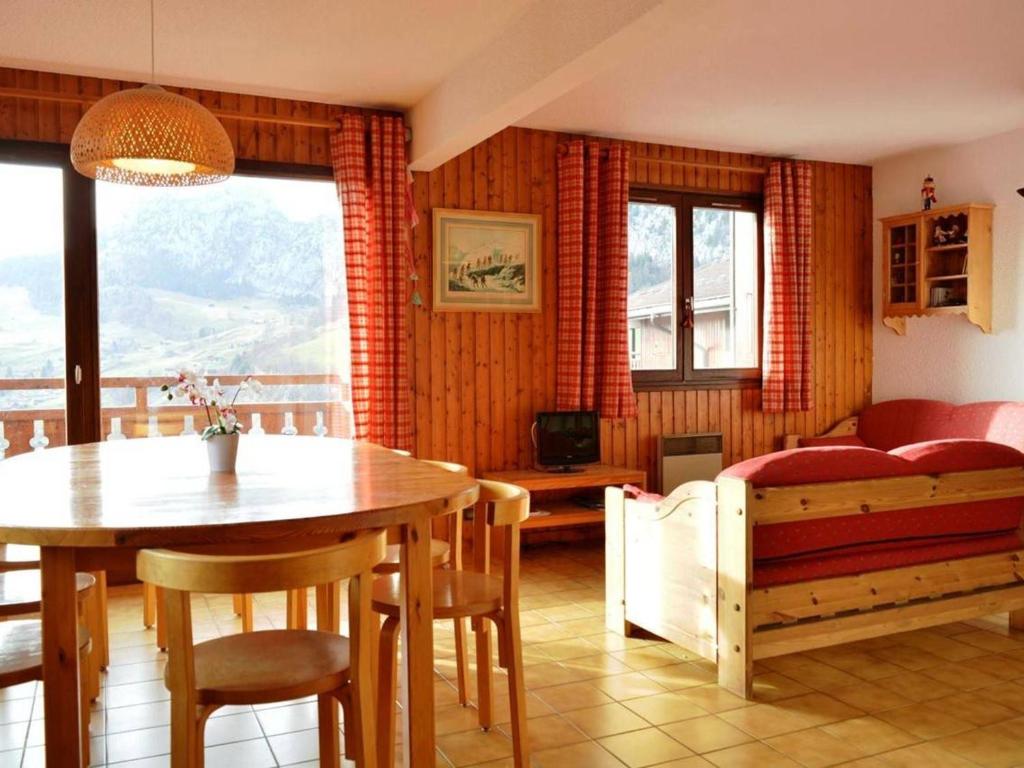 a living room with a table and a bed at Appartement Le Grand-Bornand, 3 pièces, 6 personnes - FR-1-241-171 in Le Grand-Bornand