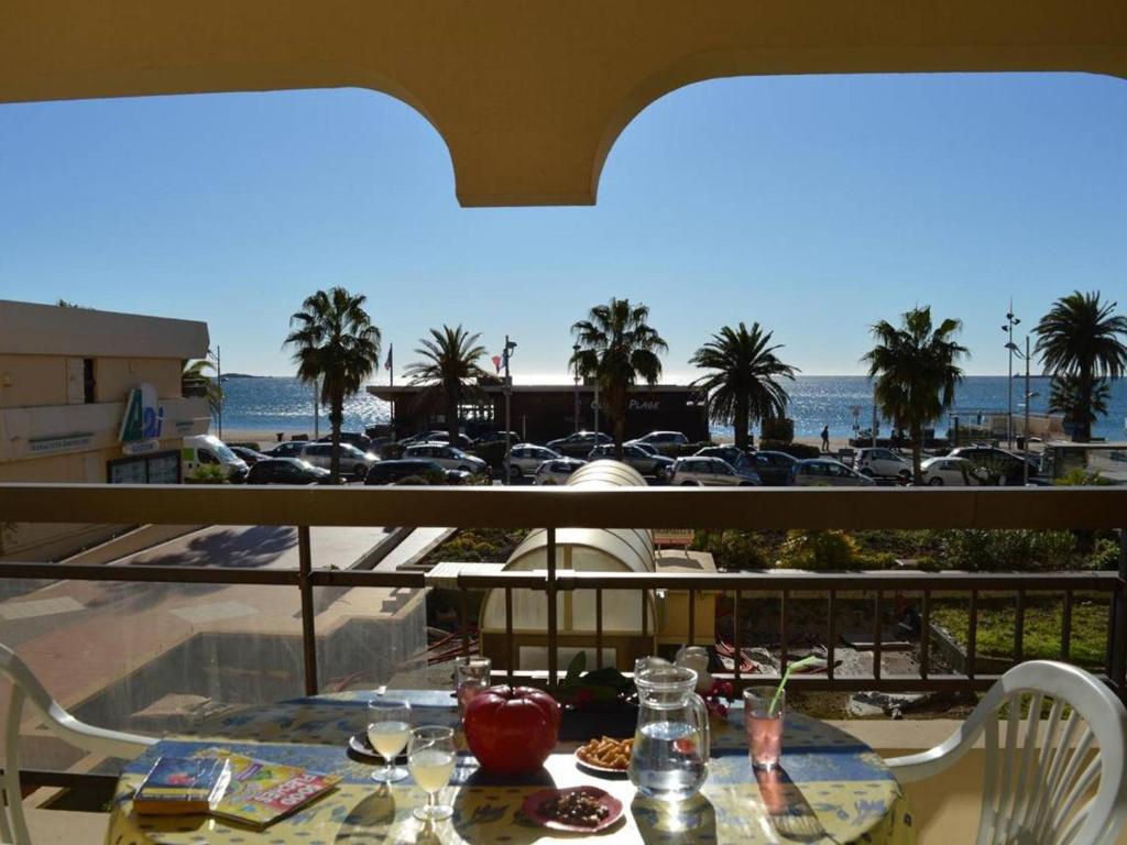 una mesa en un balcón con vistas a un aparcamiento en Appartement Fréjus, 1 pièce, 4 personnes - FR-1-226A-293, en Fréjus