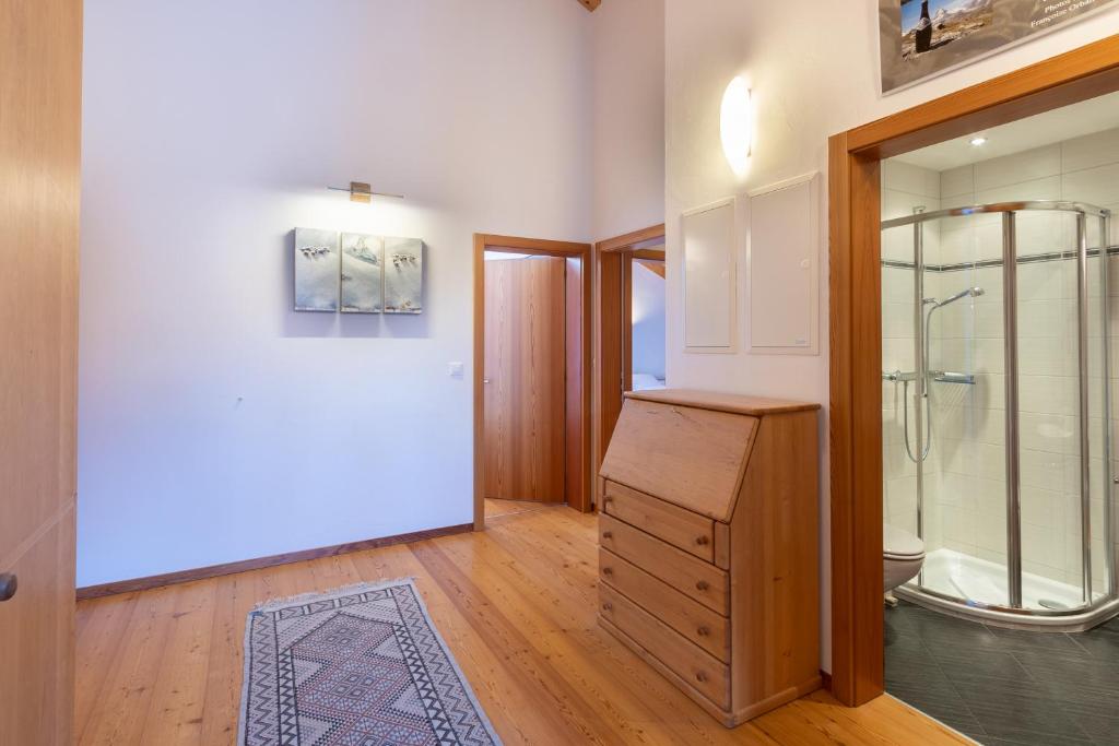 baño con ducha a ras de suelo y puerta de cristal en Haus Malva, en Zermatt