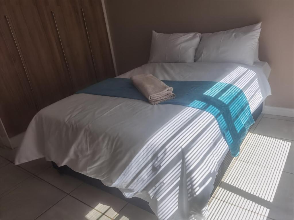 a bed with a towel sitting on top of it at Three Bedroom Apartment At The Blyde in Boschkop