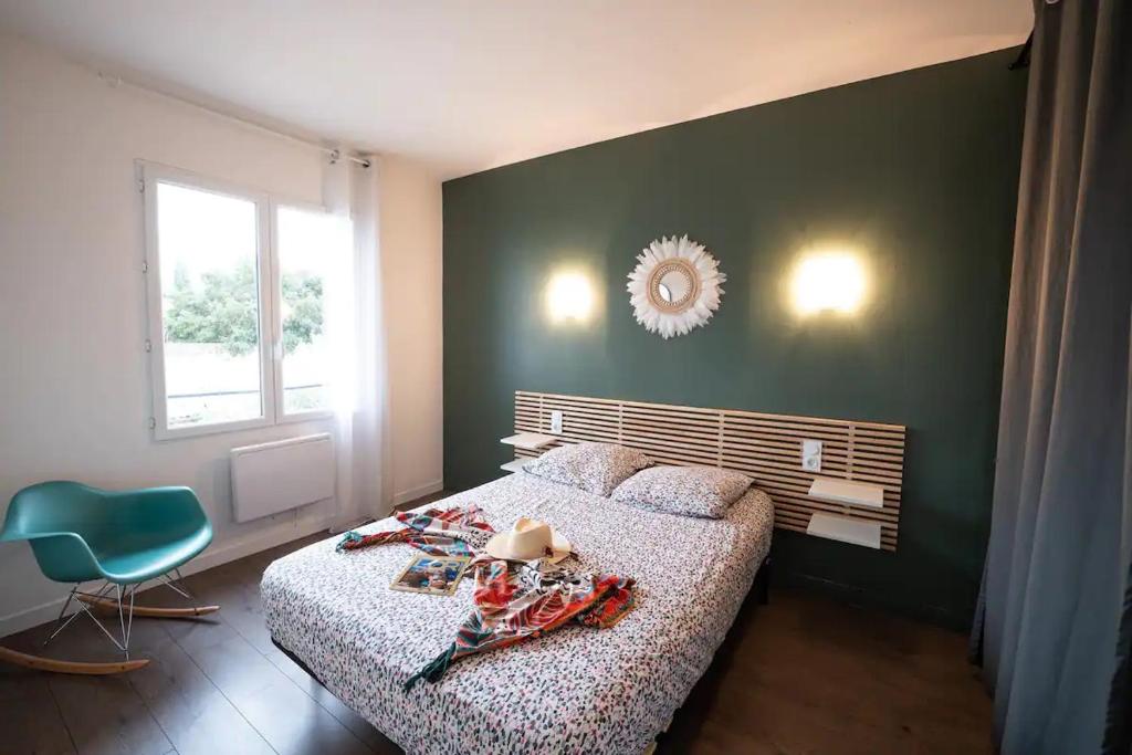 1 dormitorio con 1 cama y 1 silla azul en appartement n2 centre village, clim, parking gratuit, en Aigues-Mortes