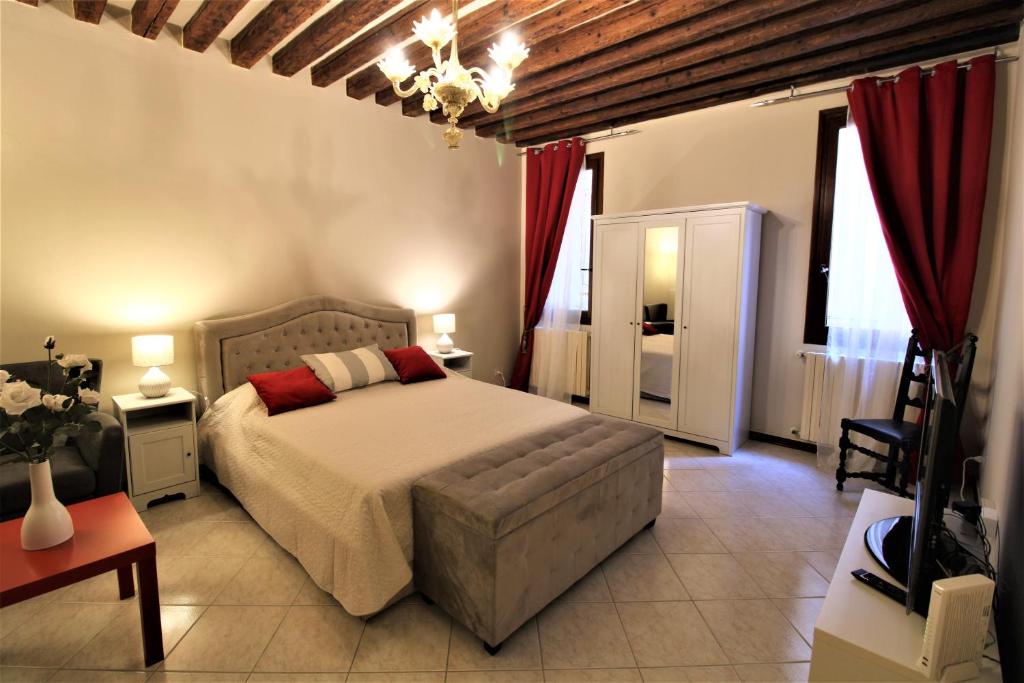 een slaapkamer met een groot bed en rode gordijnen bij CENTRAL AND SPACIOUS APARTMENT in Venetië