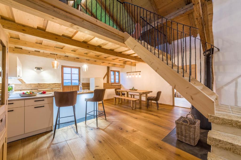 eine Küche und ein Esszimmer mit einer Treppe in einem Blockhaus in der Unterkunft Ferienwohnung Weitblick in Eggstätt