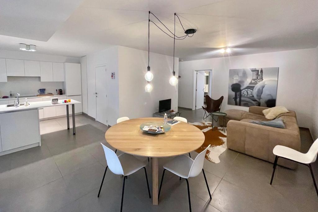 a kitchen and a living room with a table and chairs at Apartment with free covered parking - City Center in Ghent