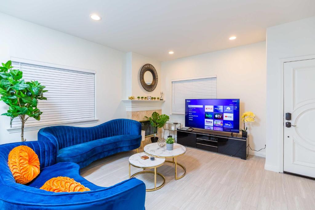 uma sala de estar com sofás azuis e uma televisão em Newly Remodeled 5B4B 2 mile from the Rose Parade em Pasadena
