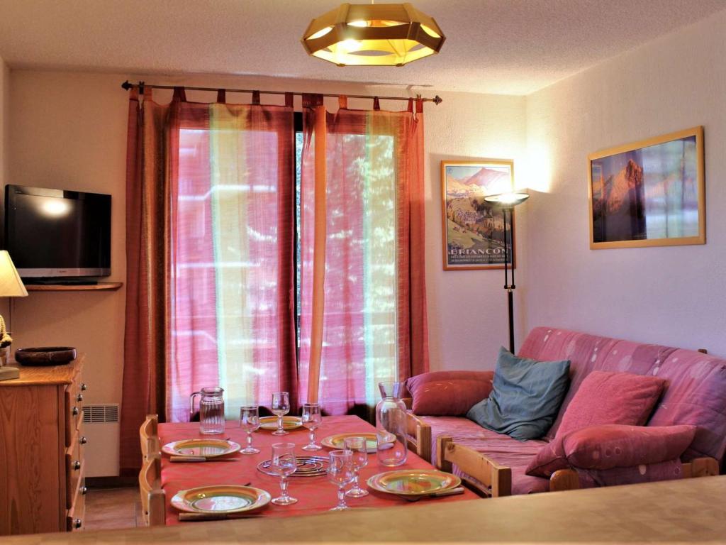 a living room with a table and a couch at Appartement au pied des pistes avec balcon à Risoul - FR-1-330-146 in Risoul
