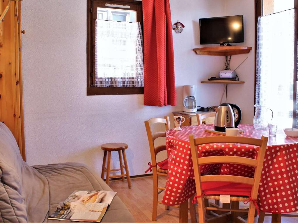 a dining room with a table with a red curtain at Appartement cosy avec 5 couchages, centre de station Risoul 1850, proche remontées et commerces - FR-1-330-162 in Risoul