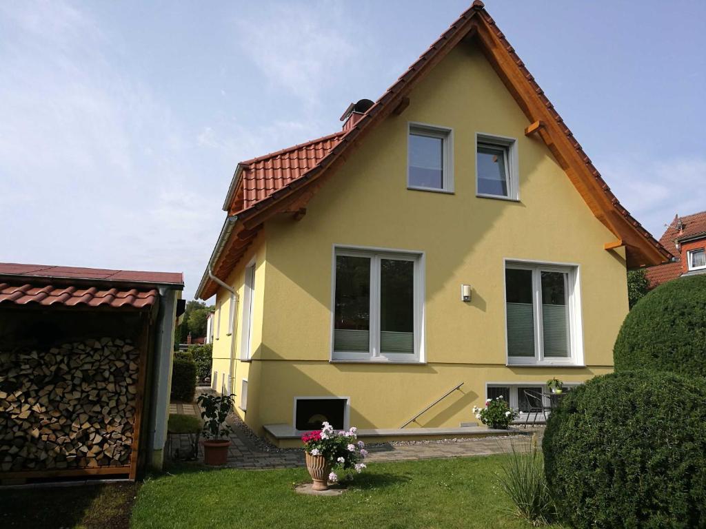 ein gelbes Haus mit rotem Dach in der Unterkunft Ferienwohnung Vaßmer in Ahlbeck