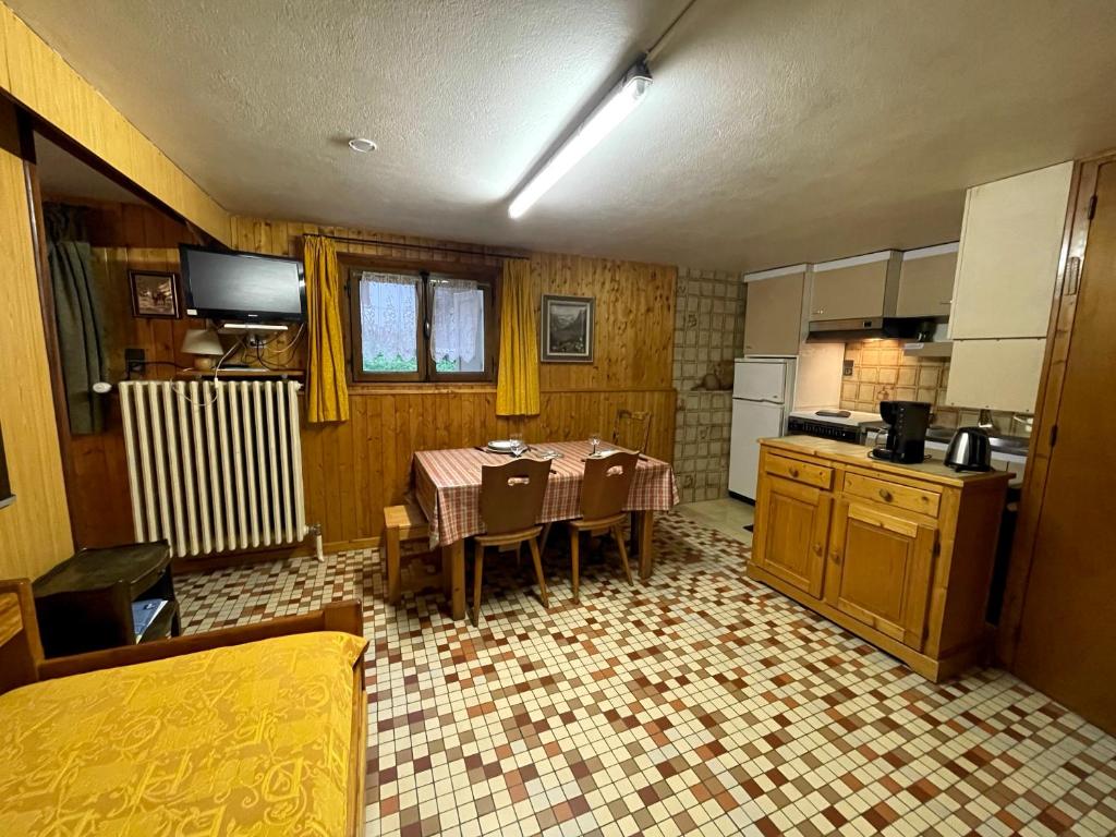 une cuisine avec une table et des chaises dans une pièce dans l'établissement GENTIANES 0-Studio basic proche pistes 4 pers, à La Clusaz