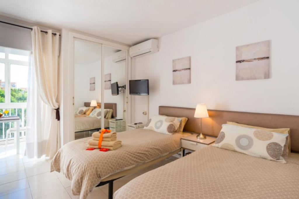 sypialnia z dwoma łóżkami i oknem w obiekcie 797 Holiday Rentals- Luminoso estudio en Arroyo de la Miel w mieście Benalmádena