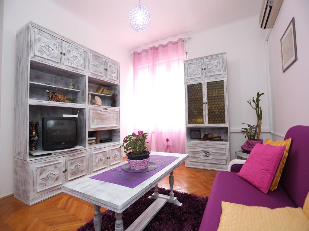 a living room with a table and a tv at Apartment Liatris in Split