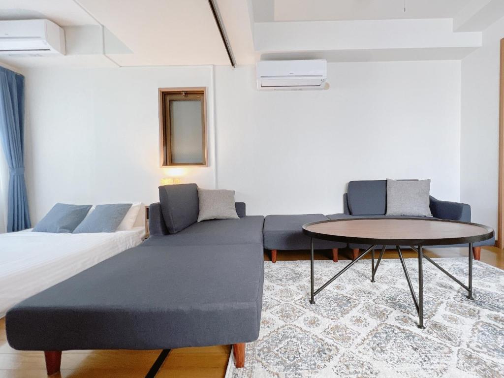 a bedroom with a bed and a table at PINE TREE HOTEL in Hiroshima