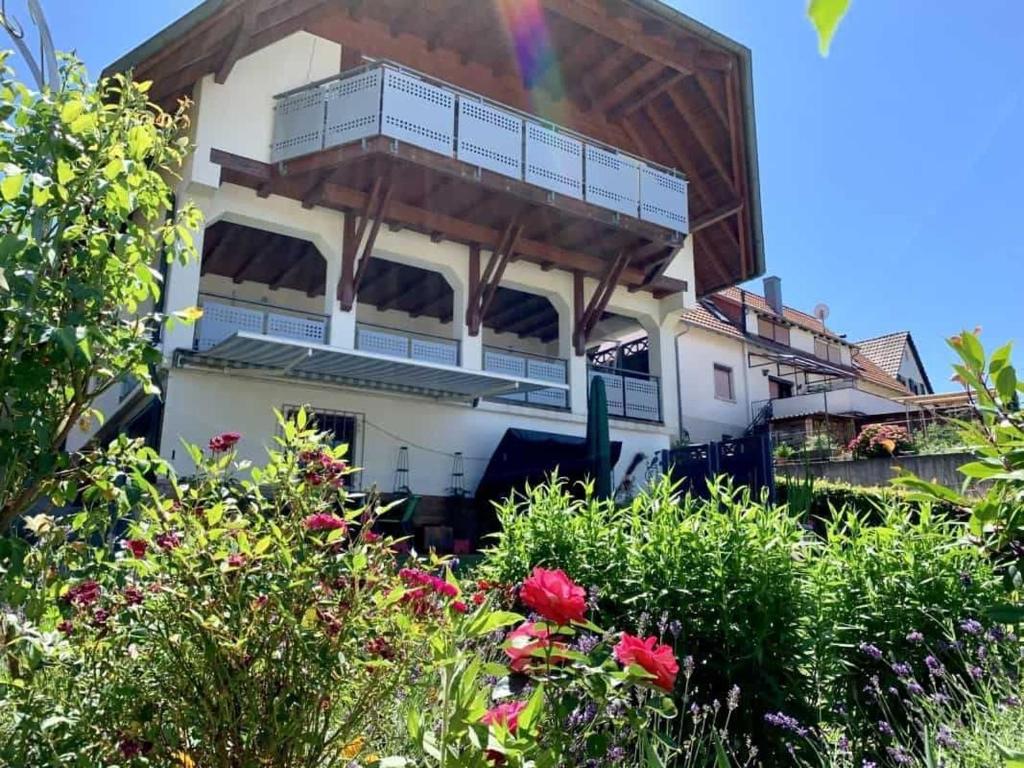 ein Haus mit einem Balkon inmitten eines Gartens in der Unterkunft Ferienwohnung Kopf in Schuttertal