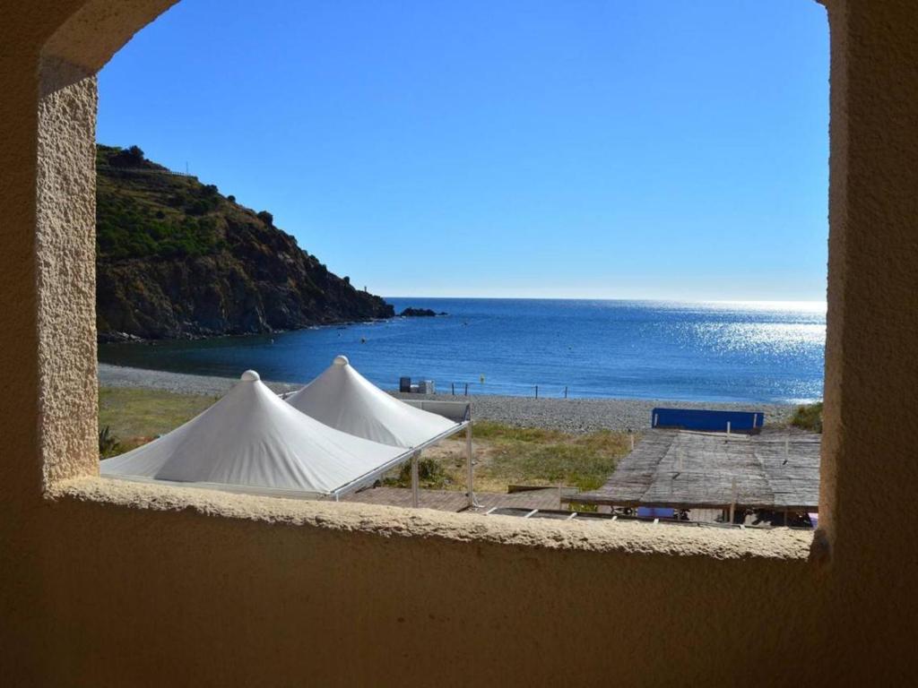 2 tentes sur une plage avec l'océan en arrière-plan dans l'établissement Appartement 3 pièces, 6 couchages avec parking à Cerbère - FR-1-225C-430, à Cerbère