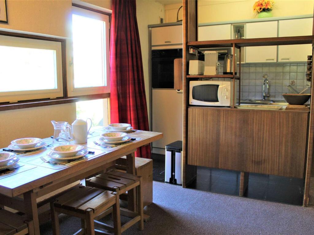 - une cuisine avec une table et de la vaisselle dans l'établissement Appartement au cœur de Vars Les Claux, proche pistes et commerces, 2 pièces, coin montagne, 5 pers. - FR-1-330B-32, à Vars