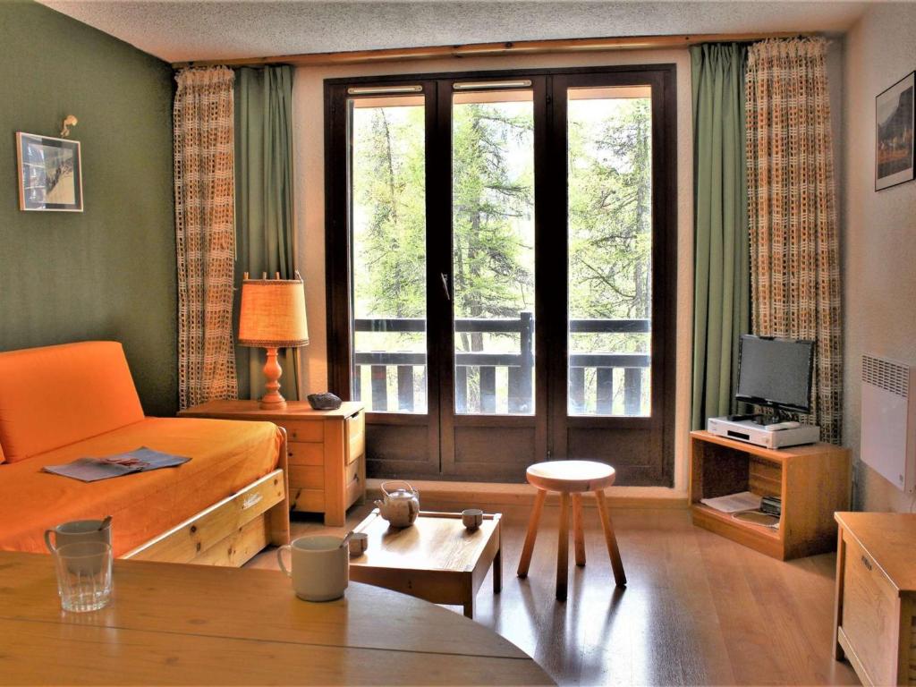 a living room with a large window and a couch at Studio 4 couchages à Risoul 1850 - pied de pistes, calme, balcon exposé Sud - FR-1-330-58 in Risoul