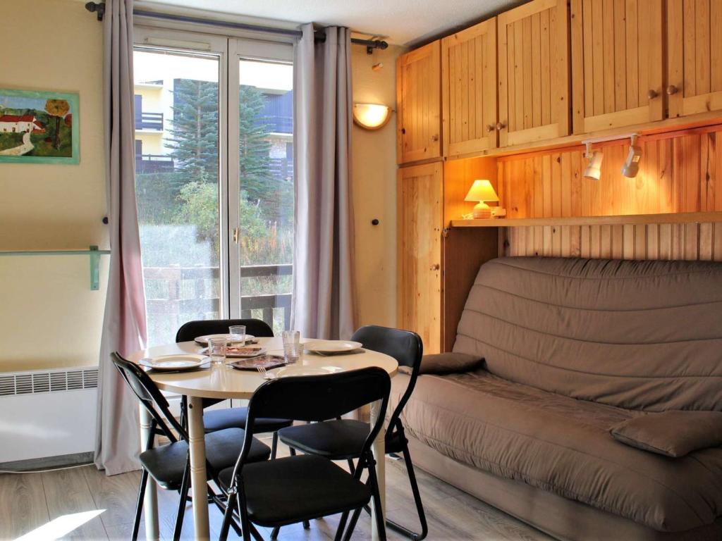 リスルにあるAppartement Risoul, 1 pièce, 4 personnes - FR-1-330-86のテーブル、椅子、ベッドが備わる客室です。