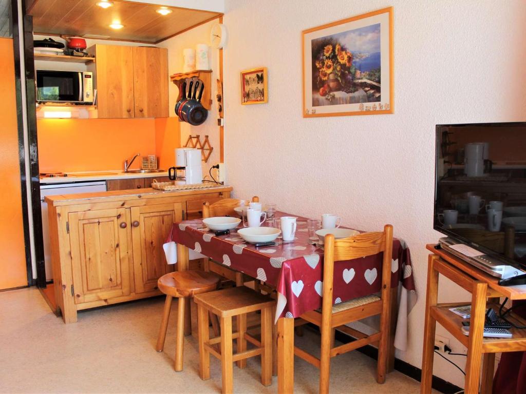 una cucina con tavolo e sedie e una cucina con di Appartement Vars, 1 pièce, 4 personnes - FR-1-330B-38 a Vars