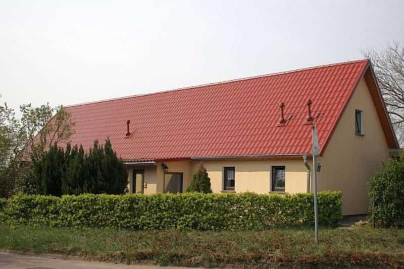 une grande maison avec un toit rouge dans l'établissement Rügen Fewo 38, à Dreschvitz