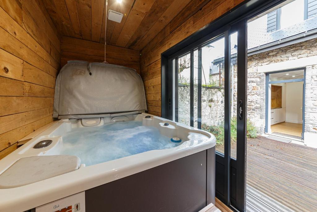 a large bath tub in a room with a window at Le Cosy de Claire in La Bourboule