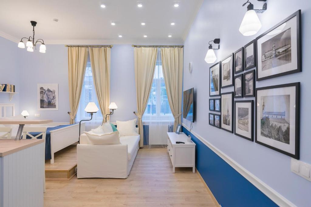 ein Wohnzimmer mit blauen Wänden und weißen Möbeln in der Unterkunft Revelton Suites Tallinn in Tallinn