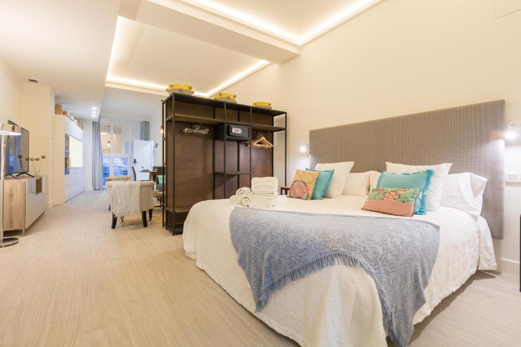 een grote slaapkamer met 2 bedden en kleurrijke kussens bij Sevilla Flats in Sevilla