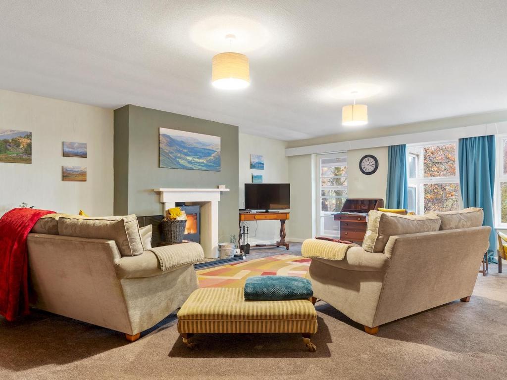 a living room with two chairs and a fireplace at Pass the Keys Cosy Home in the Idyllic Duddon Valley in Ulpha